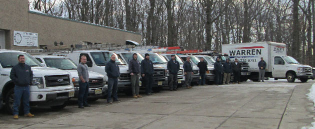 Warren Heating and Cooling technicians with service vans