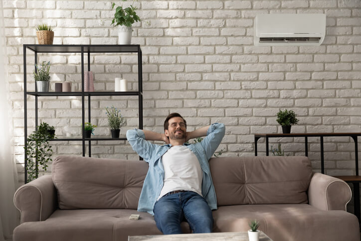 Man relaxing in room with ductless AC.