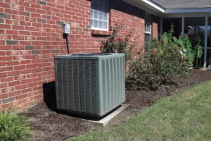 central air unit installed outside of a brick home